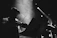 A close-up of a violinist passionately playing in a dimly lit warehouse setting.
