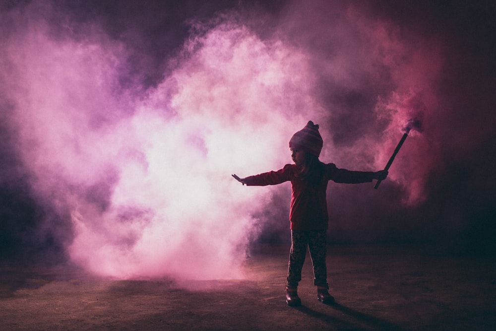 girl holding stick near smoke