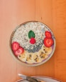 smoothie oatmeal topped with sliced of bananas and strawberries
