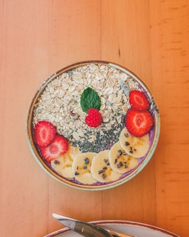 Close-up of a vibrant bowl of protein oats topped with fresh fruits and nuts, showcasing natural ingredients.