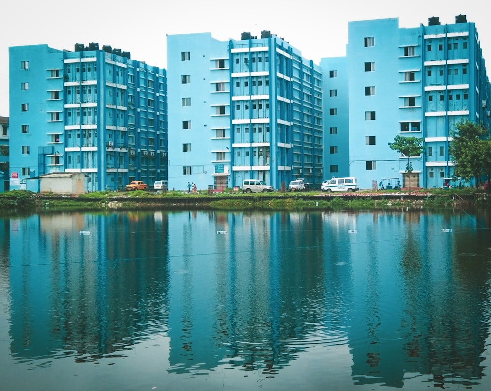 blue painted buildings beside body of water