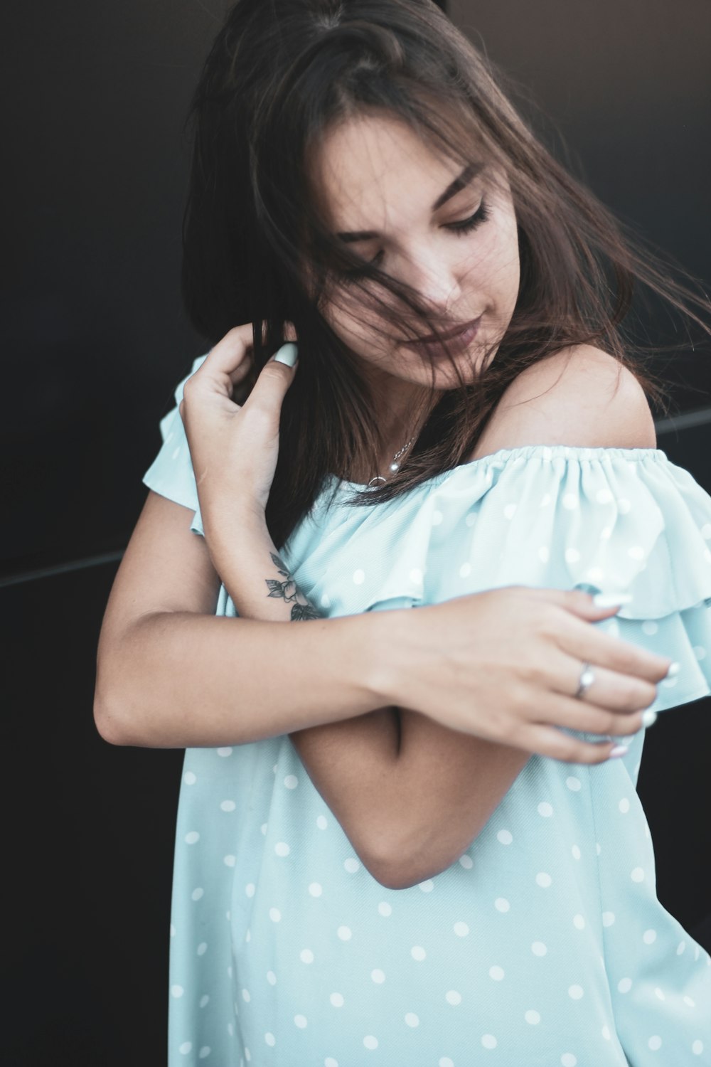 woman wearing teal and white polka-dot off-shoulder top