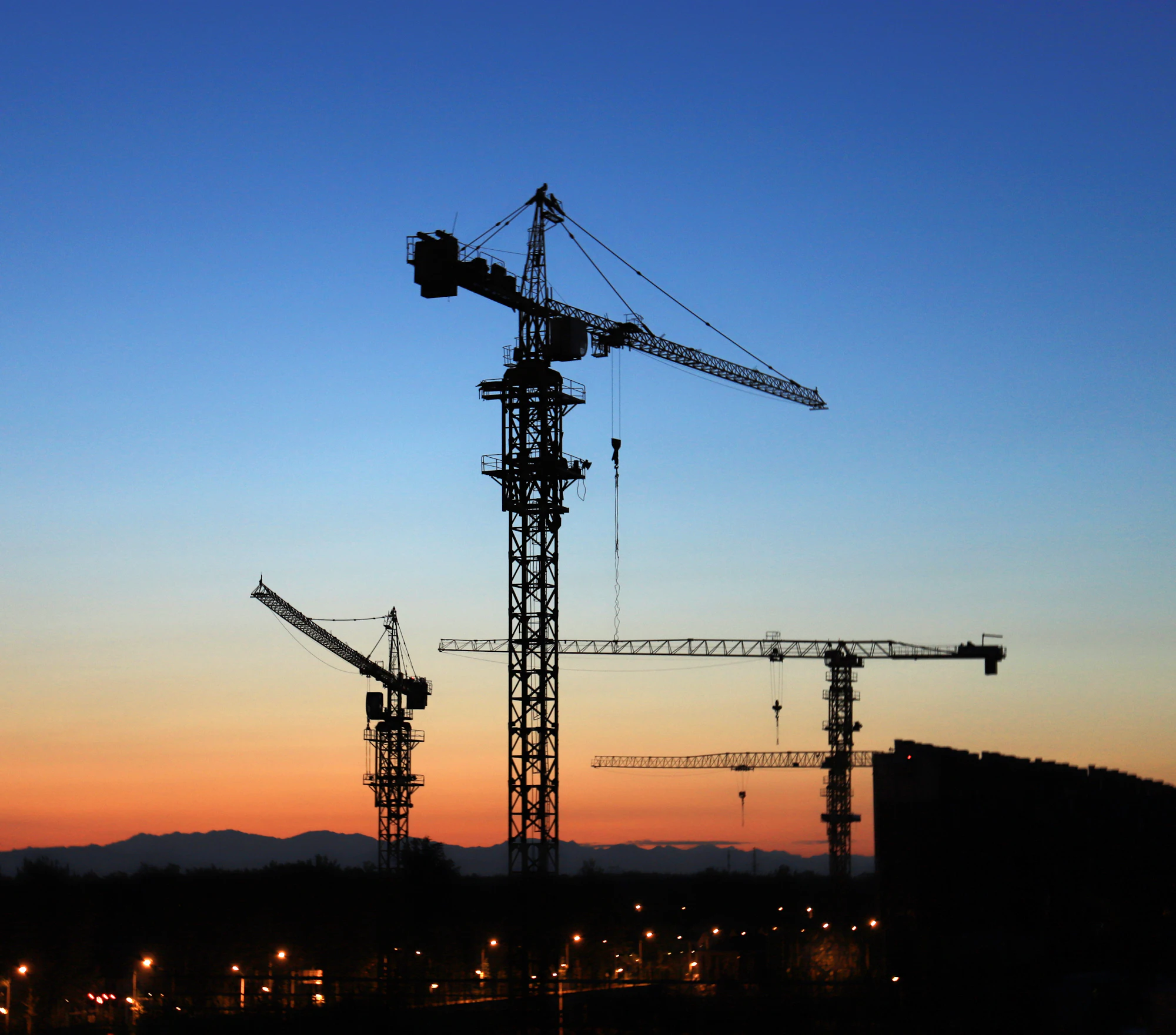 Building site with tower cranes at golden hour