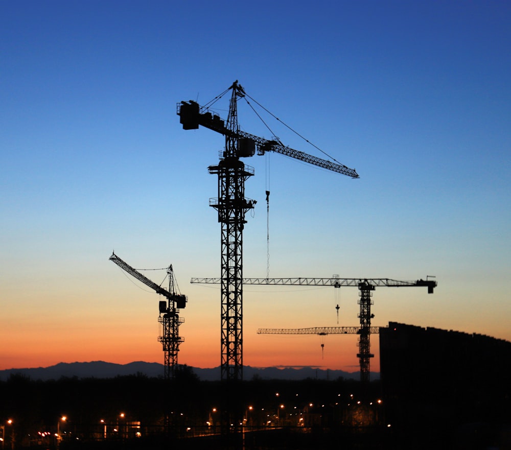 building site with tower cranes during golden hour