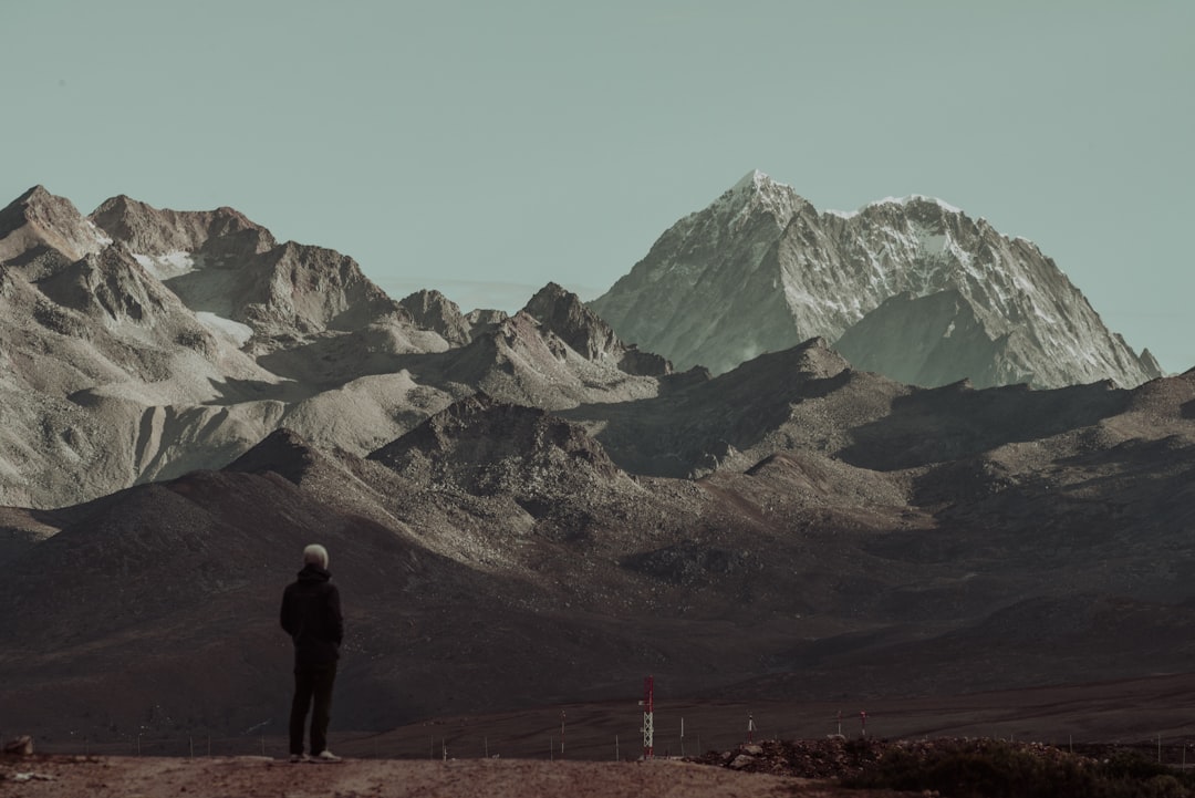 man standing looking the mountains