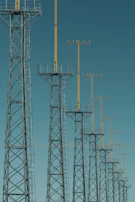 A panoramic view of multiple towers installed on a hill, with mounting brackets and antennae.