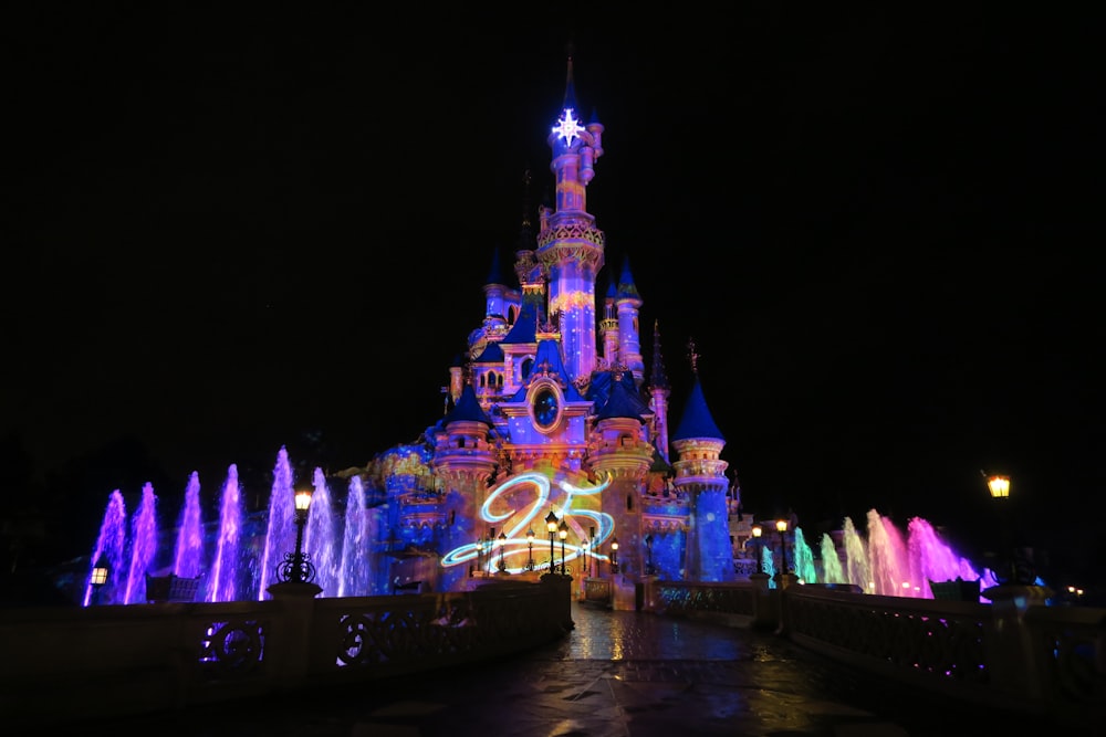 Vista del castillo iluminado de Disneyland por la noche