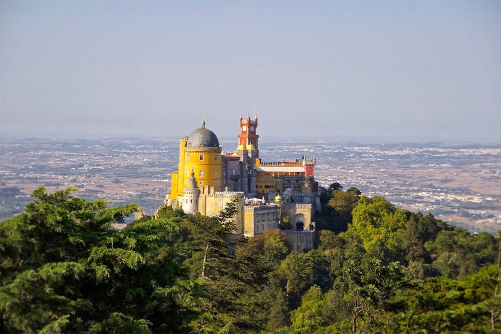 castello grigio e giallo in cima a una collina