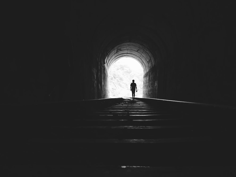 silhouette of man under tunnel