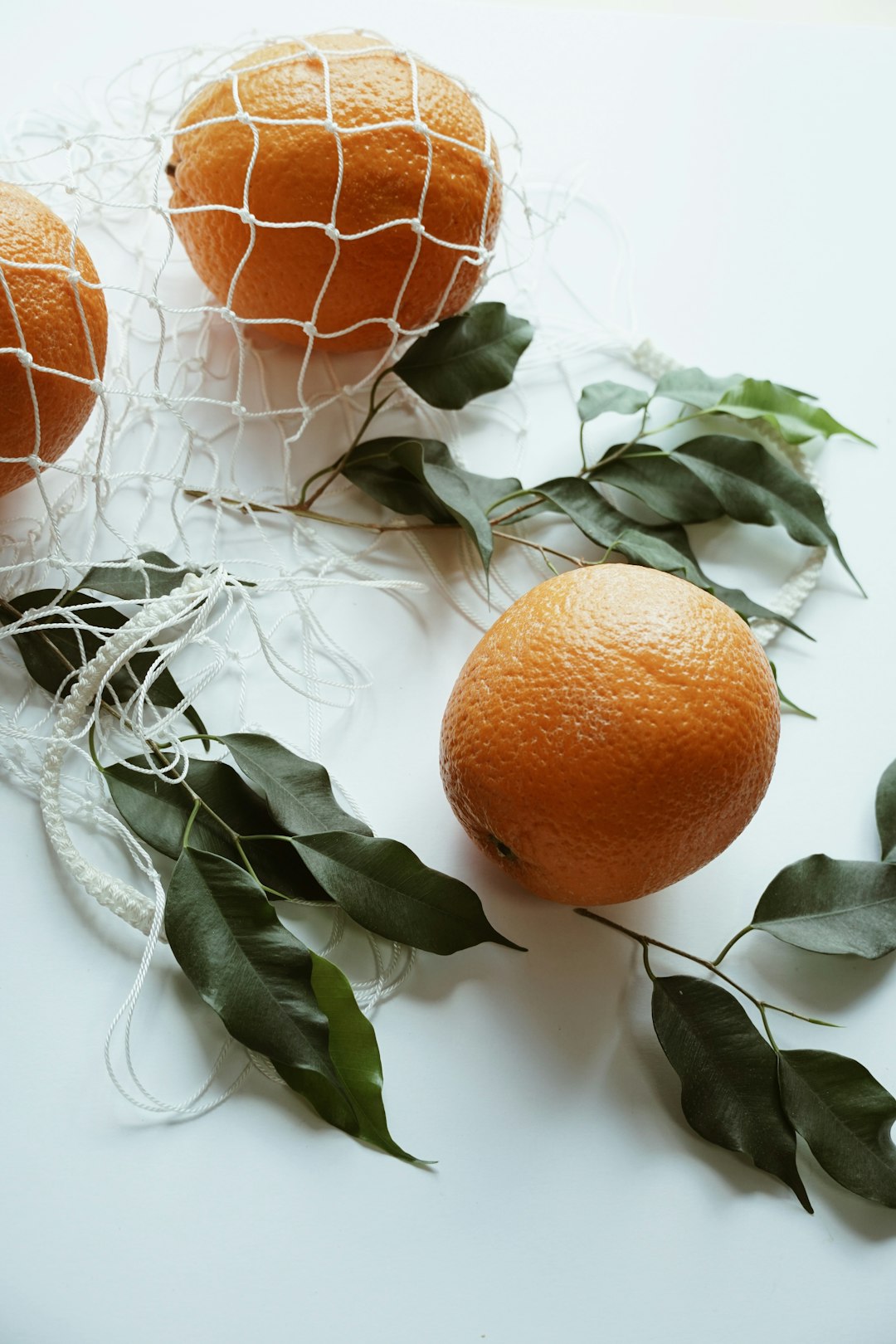 orange fruits on white surface