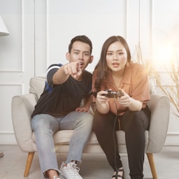 man and woman sitting on gray fabric loveseat