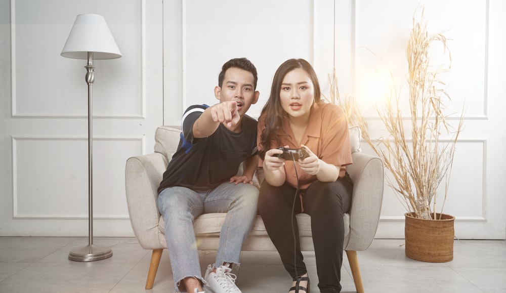 man and woman sitting on gray fabric loveseat