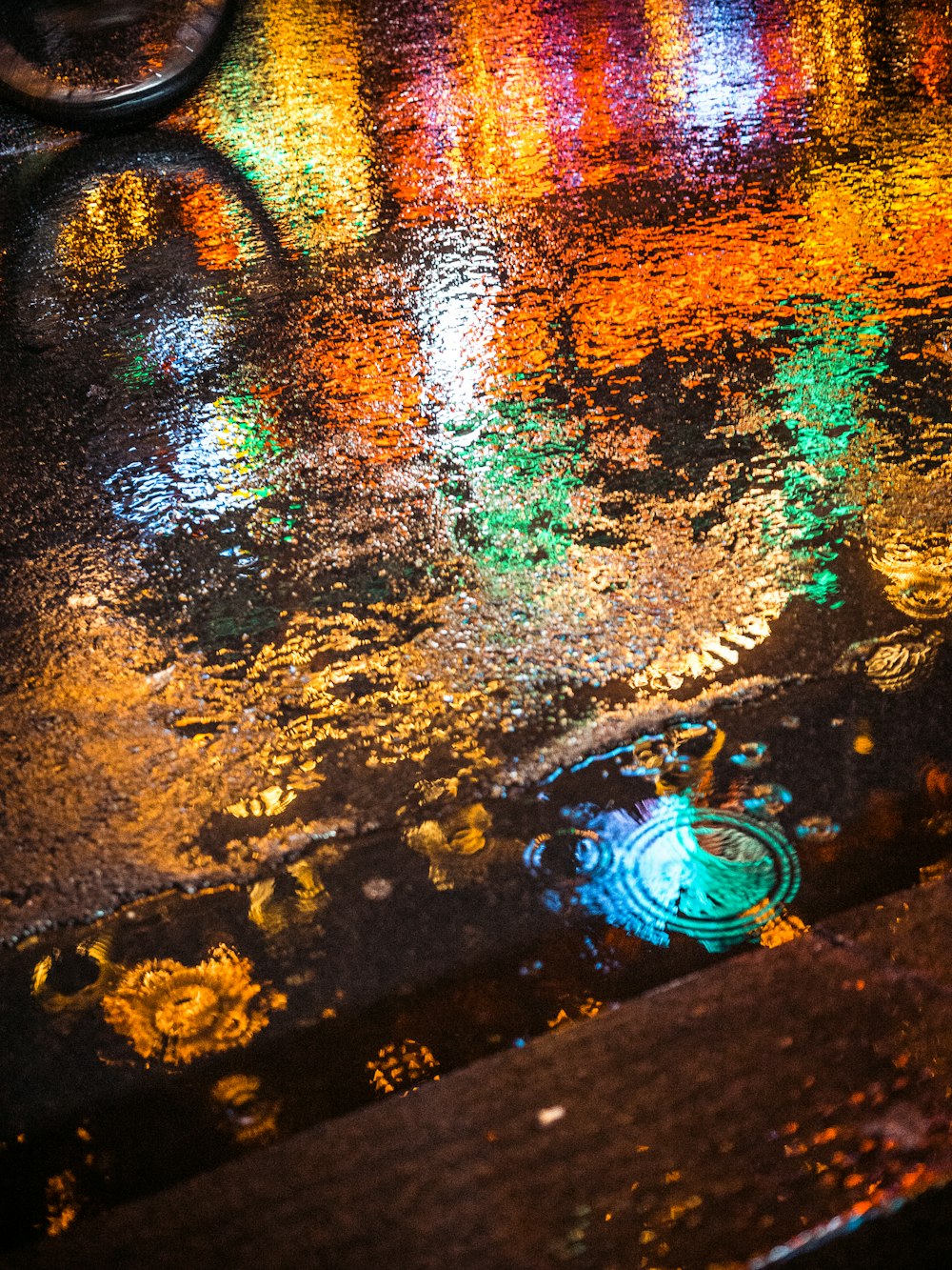 a wet sidewalk with a puddle of water on it