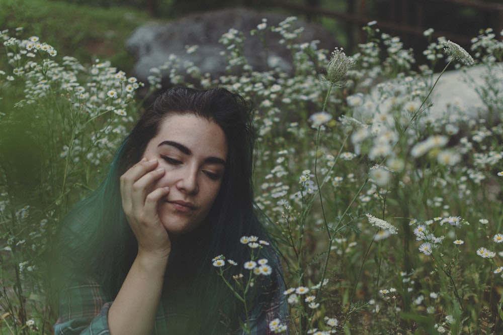 woman sitting on flowerfield