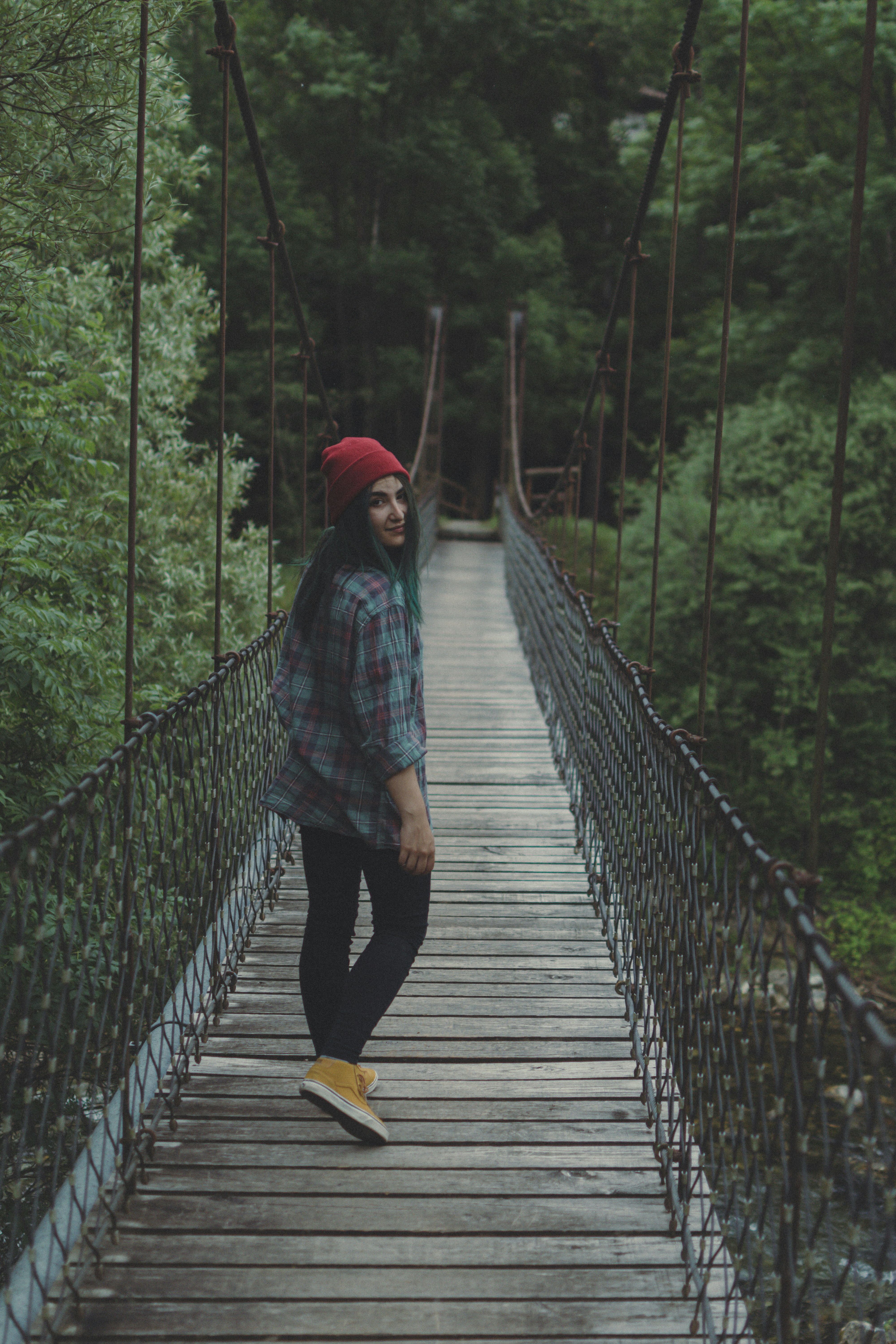 woman walking on brown wooden bridge during daytime