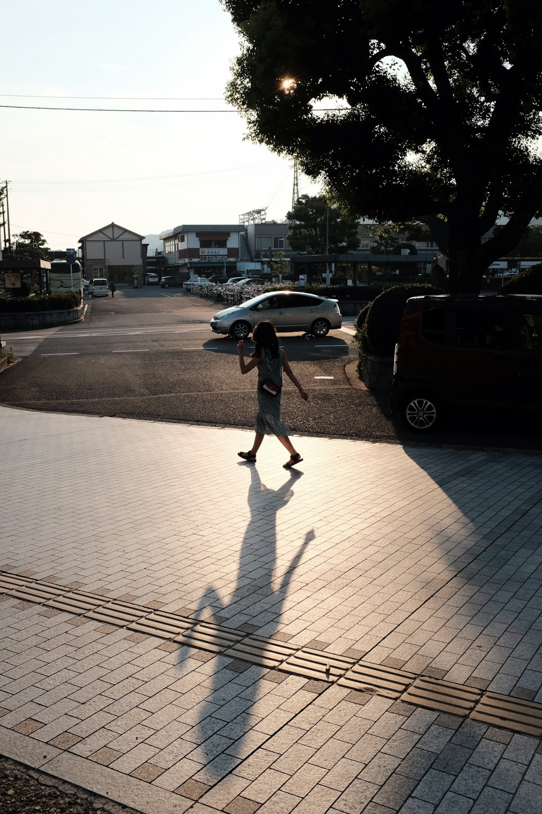girl walking on side walk during daytime