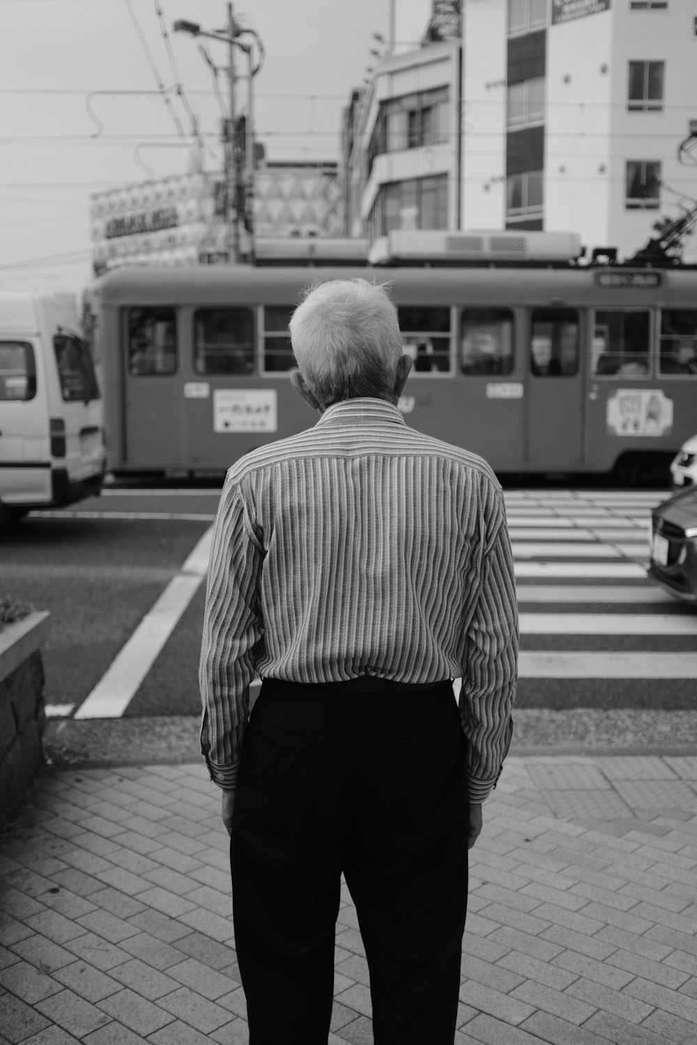 Graustufenfotografie eines Mannes, der in der Nähe der Straße steht