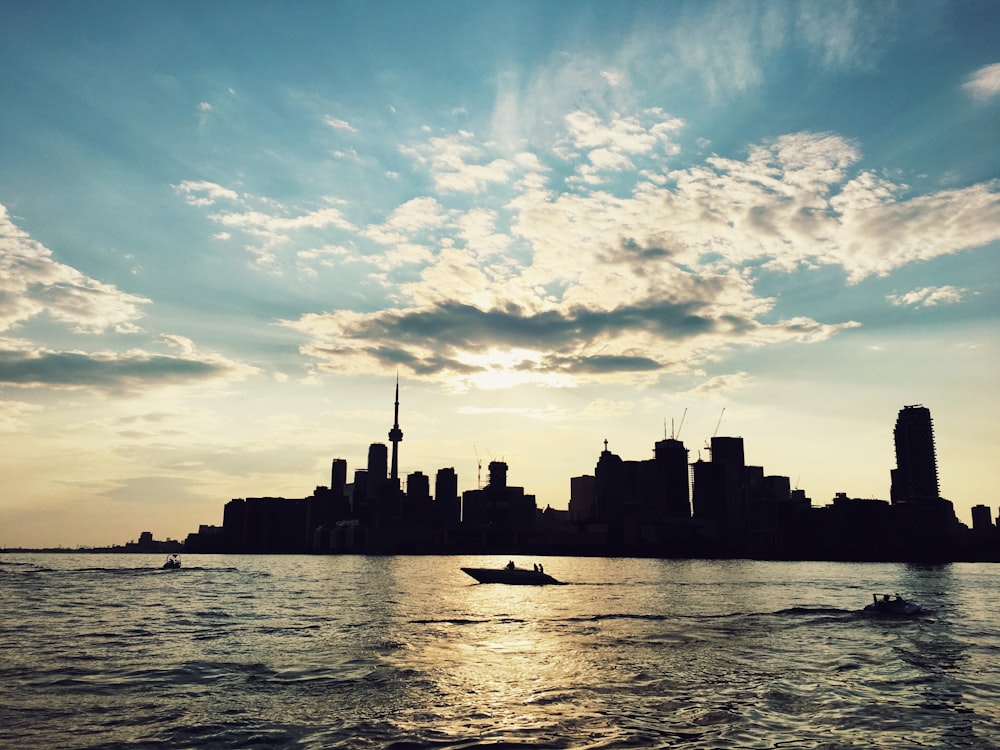 silhouette photo of buildings beside sea