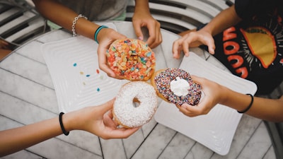 A cheerful group of people enjoying mini donuts and coffee at a festival.