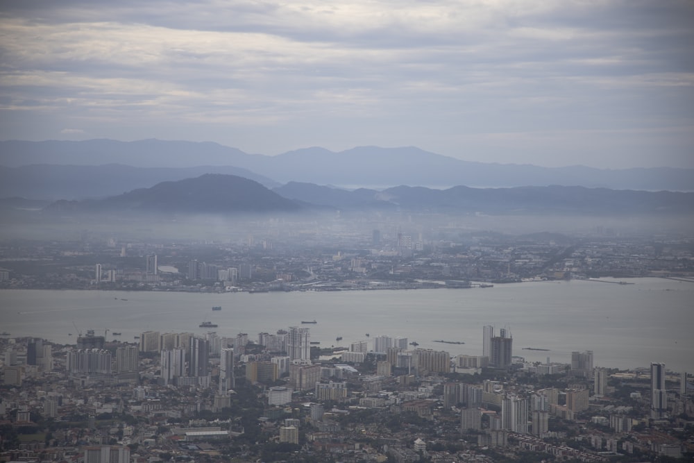 city with high-rise buildings viewing sea under blue and white skies