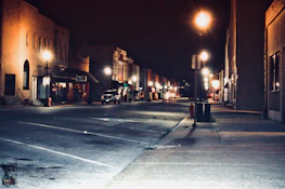 an atmospheric shot of a quiet street in metro manila at night with glowing street lamps