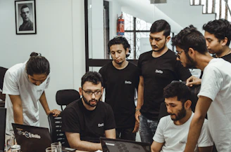 people near a black top computer in a room
