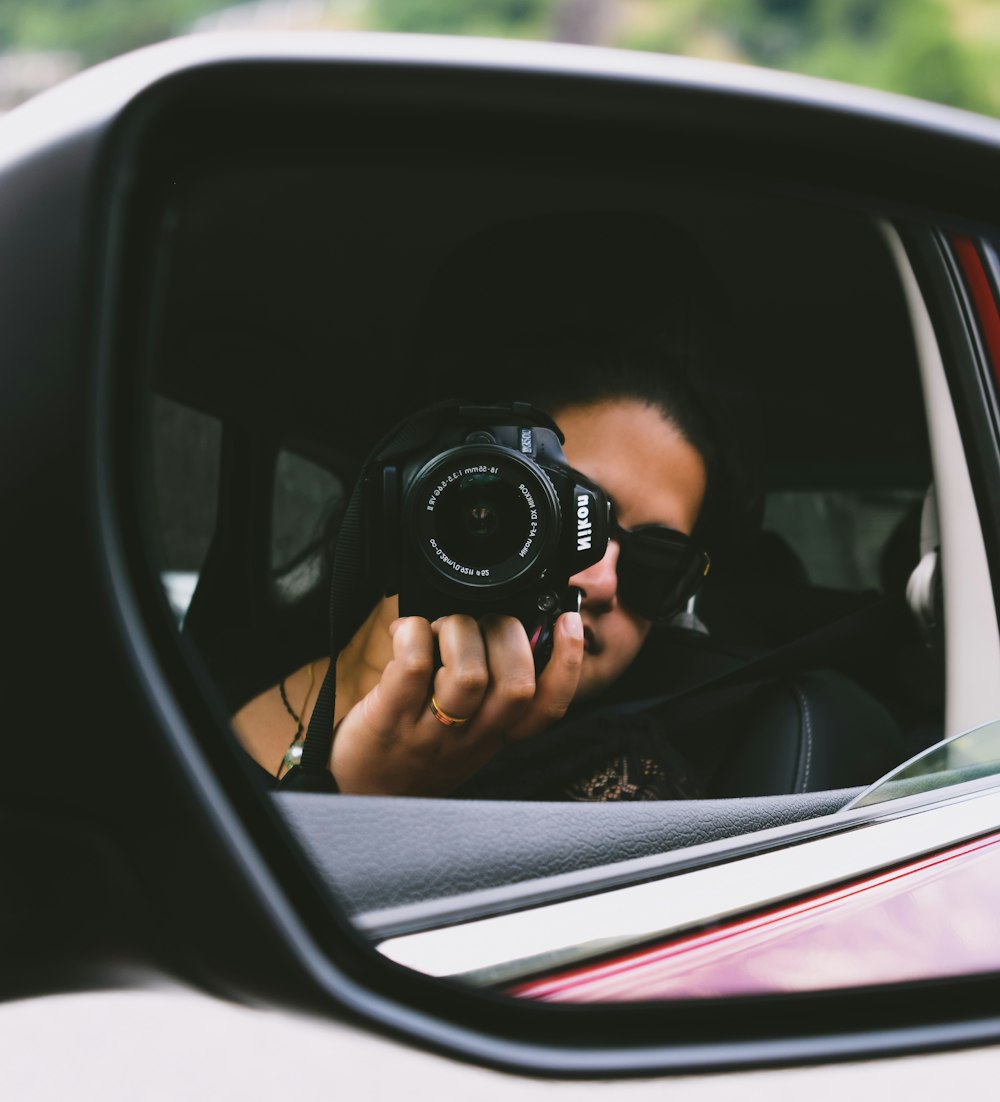 person holding camera mirror image close-up photography