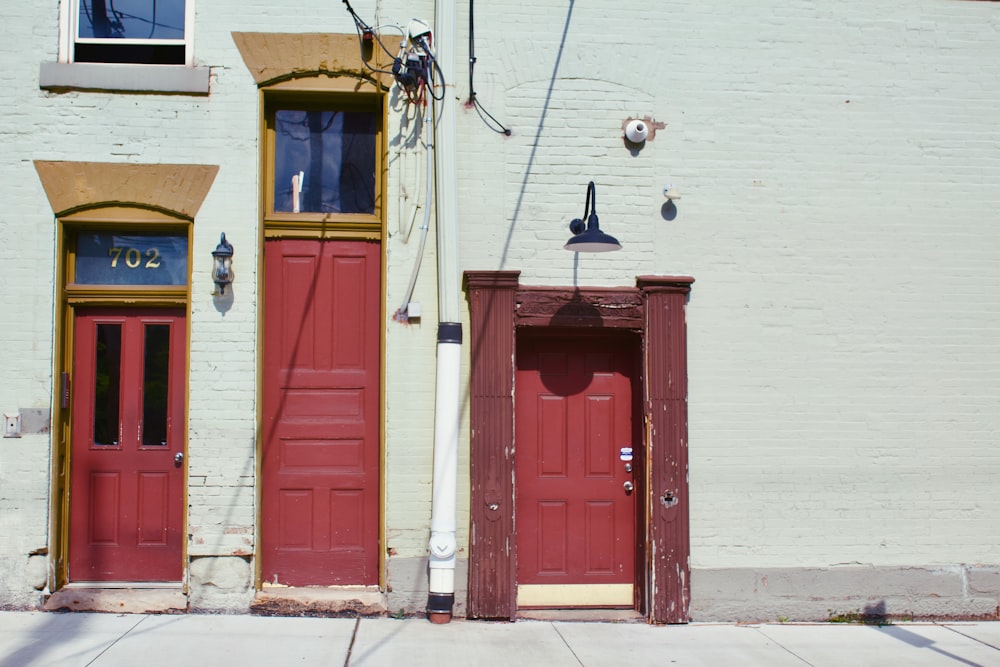 minimalist photography of three red wooden doors