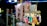 A variety of colorful items are displayed in plastic bags, hanging alongside packaged cotton candy. Each item is priced at 5000 as indicated by a sign. The scene is set in a bright, likely festive environment with various lights and decorations visible in the background.