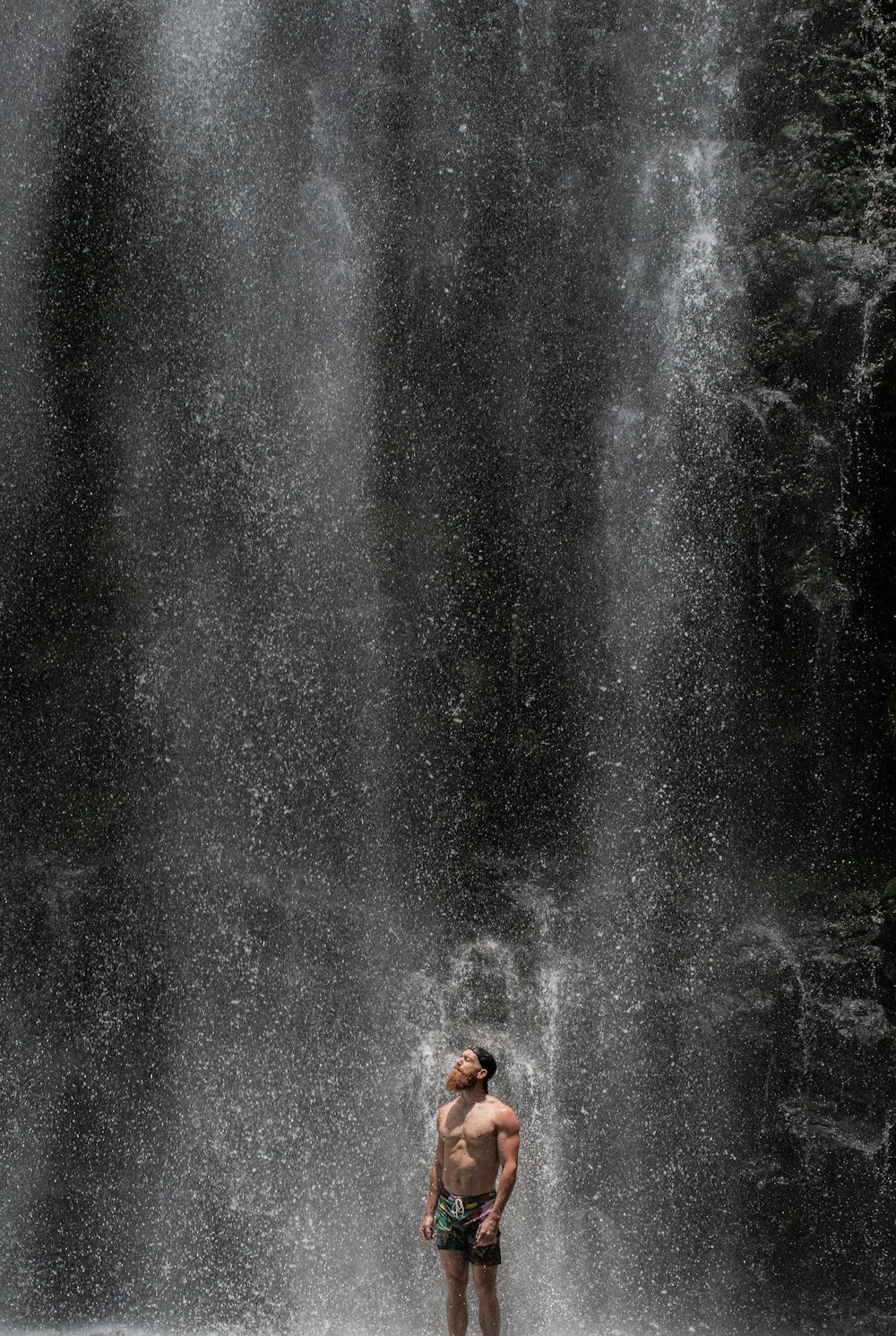 man standing near waterfalls