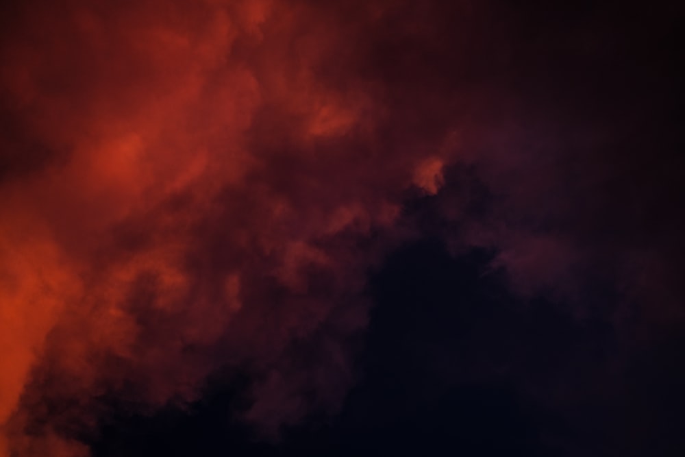 a plane flying through a cloudy sky at night