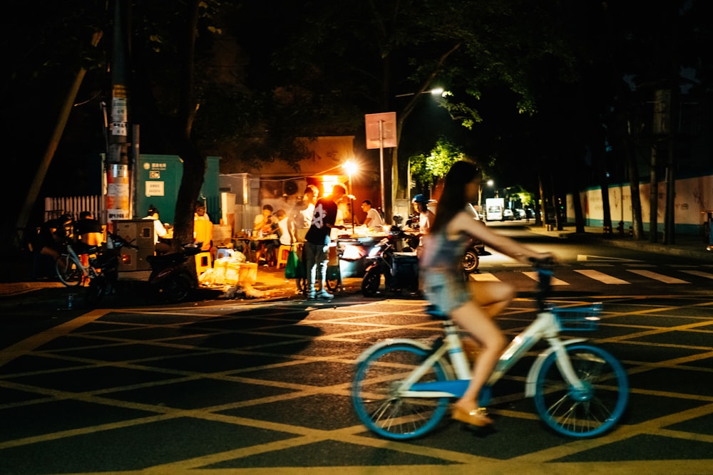 Donna che cavalca la fotografia in primo piano della bicicletta bianca e blu