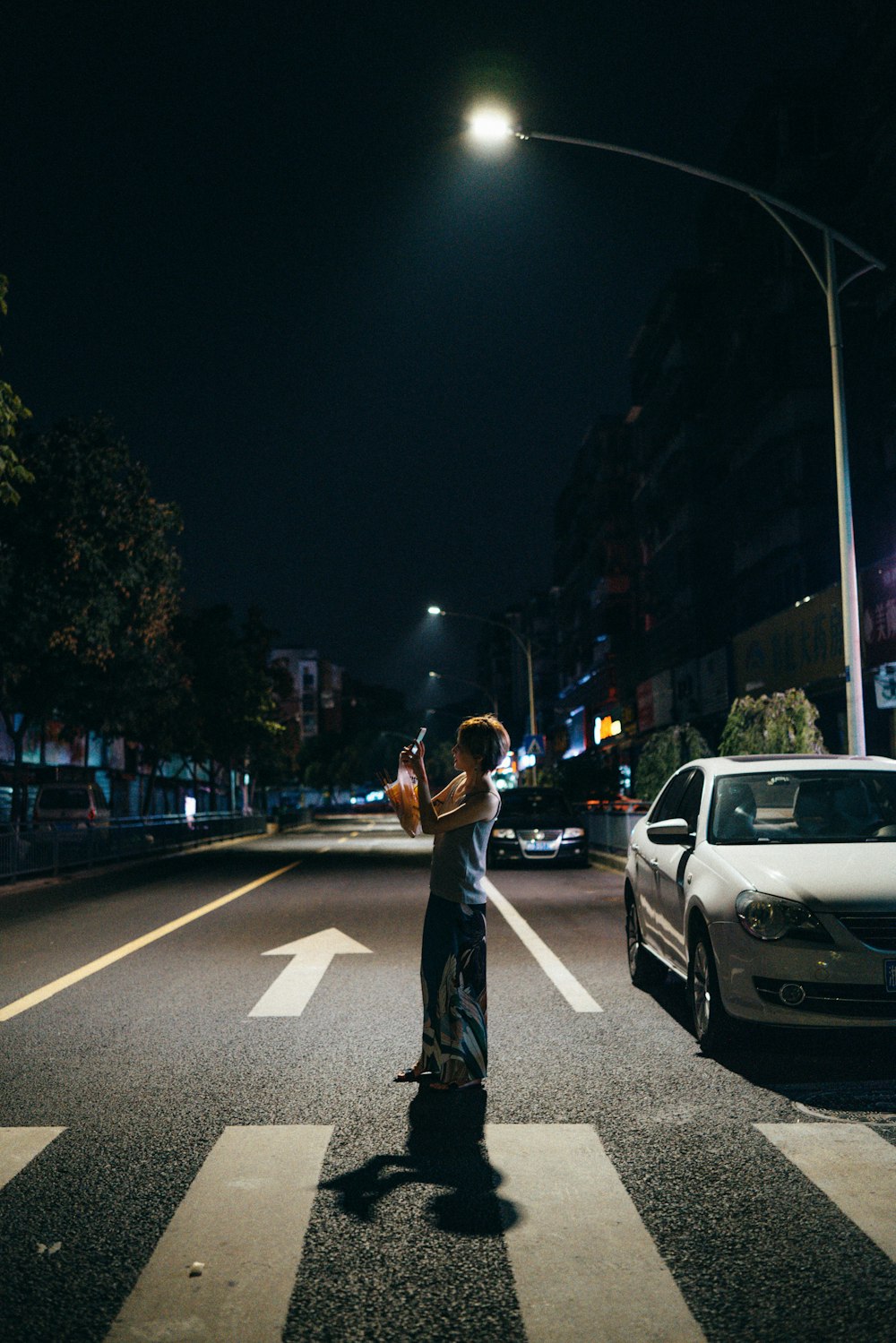 woman standing on road during nighttime