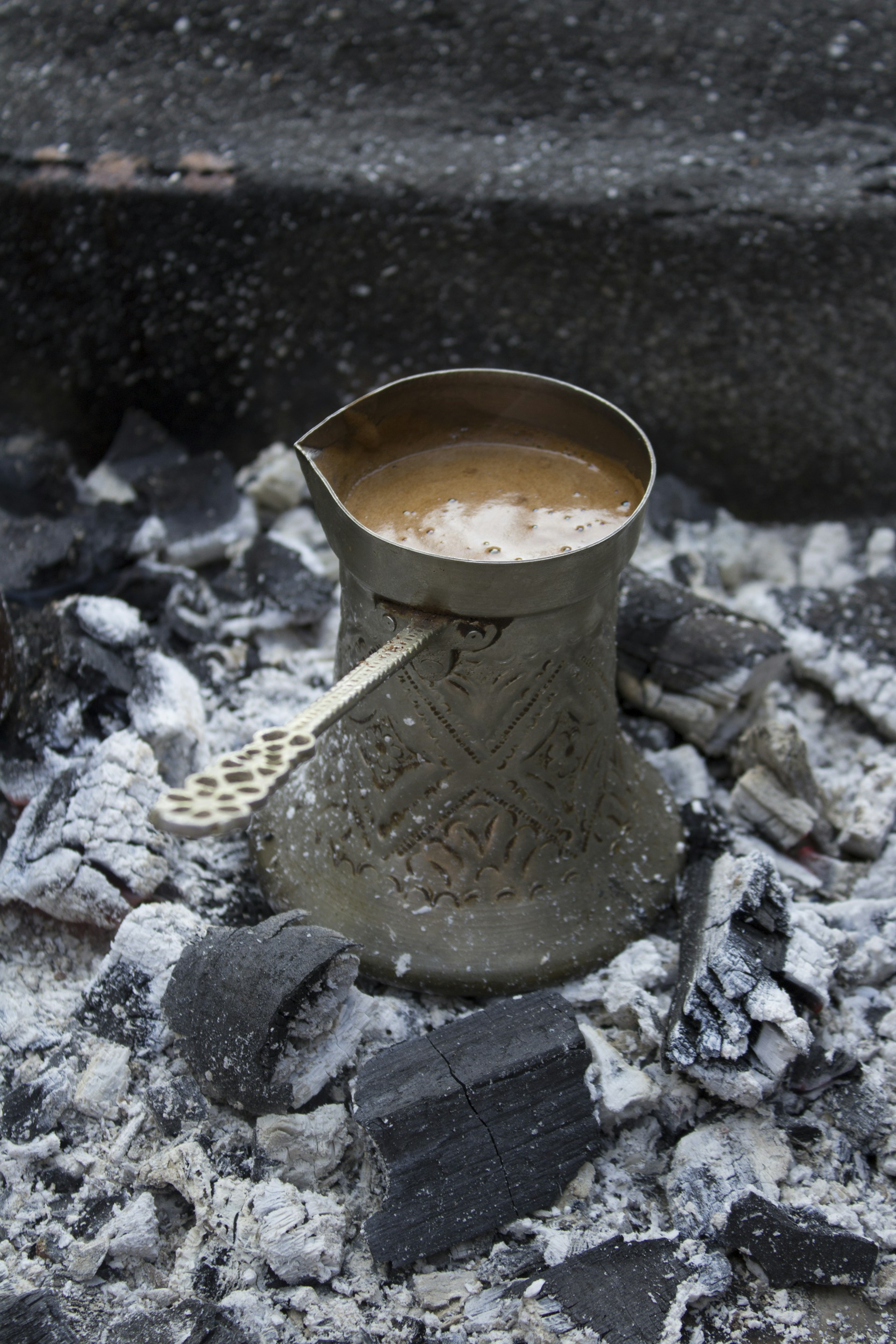 a cup of coffee sitting on top of a pile of rocks