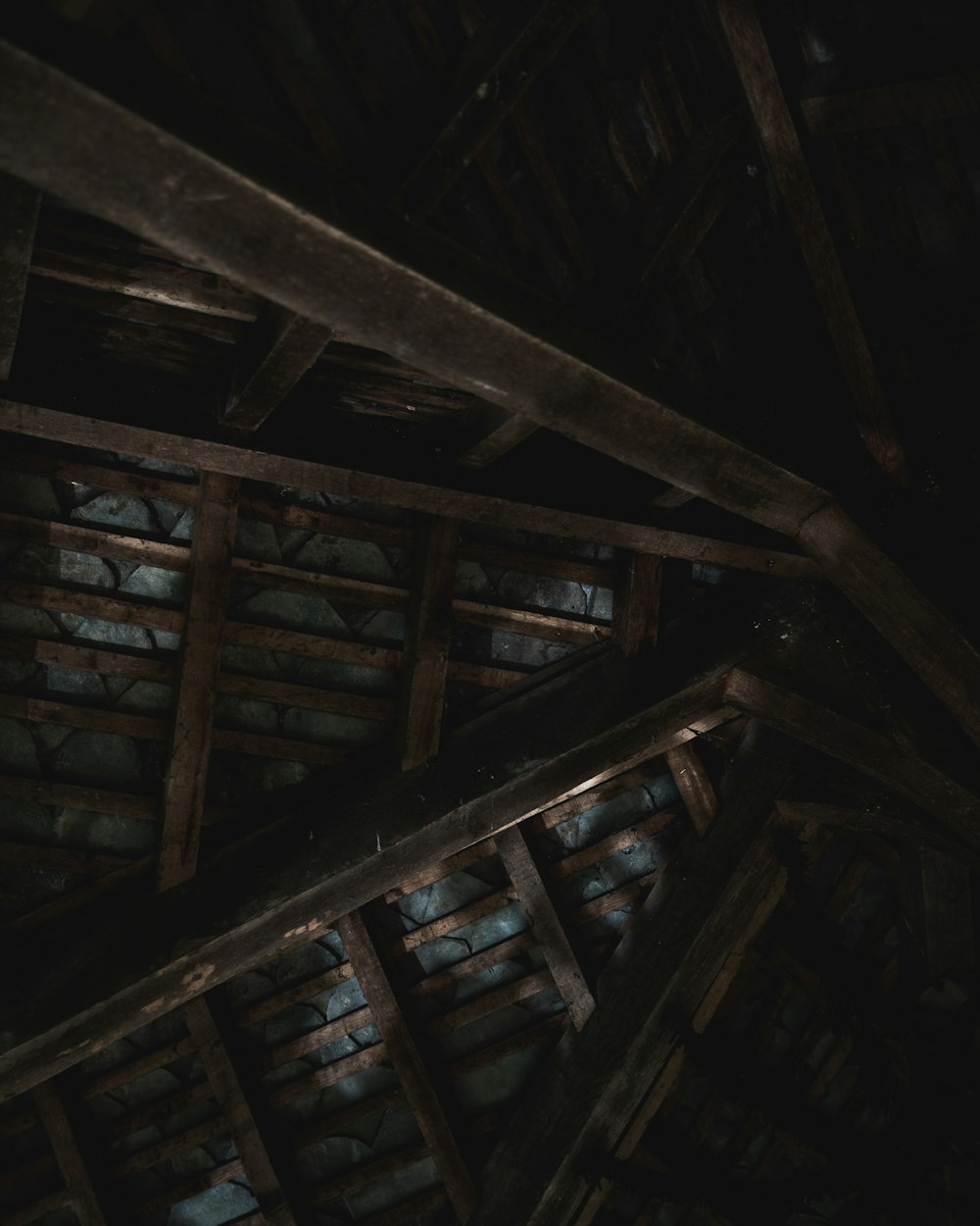 a dark room with wooden beams and a ceiling