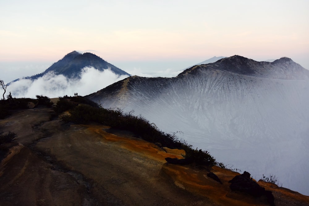 white clouds and brown-and-gray mountains