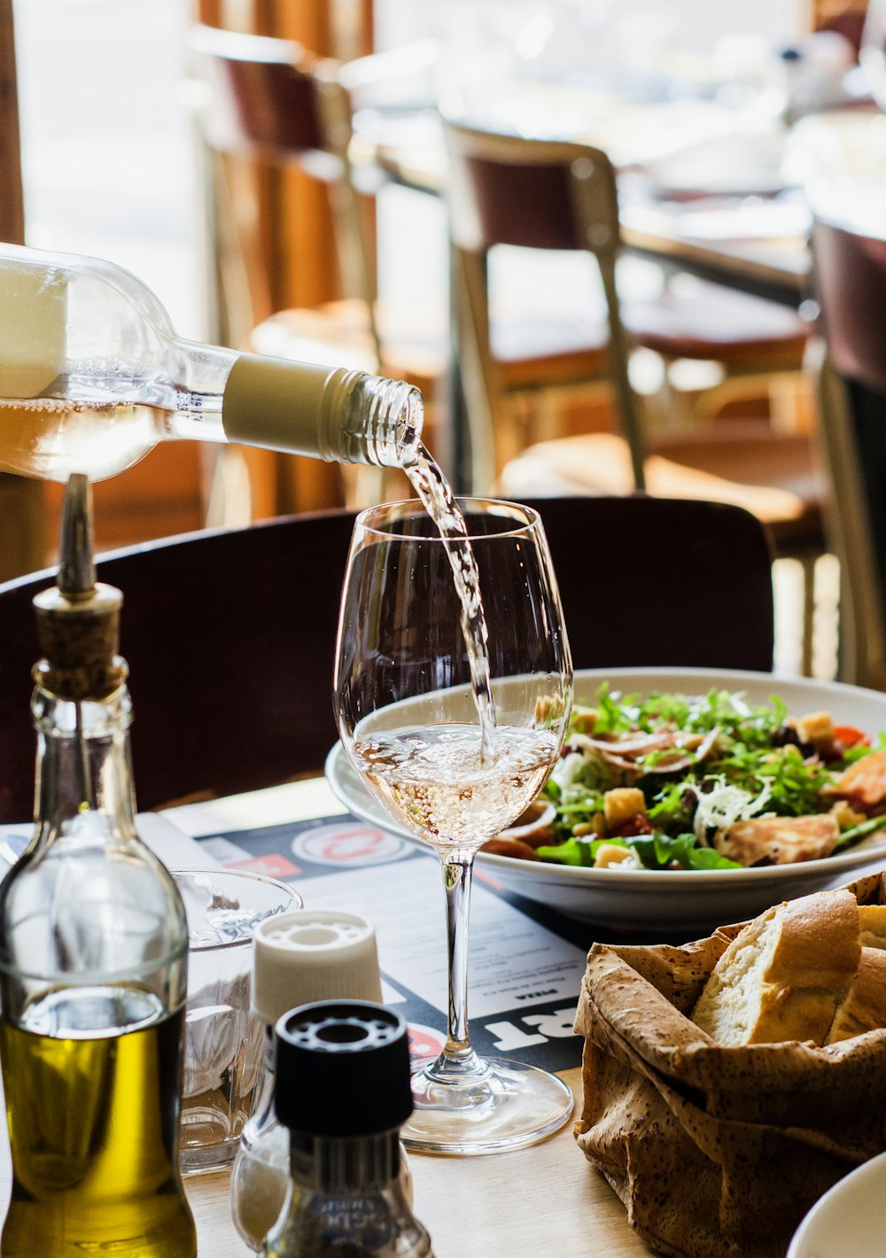 personne versant du vin dans un verre à vin