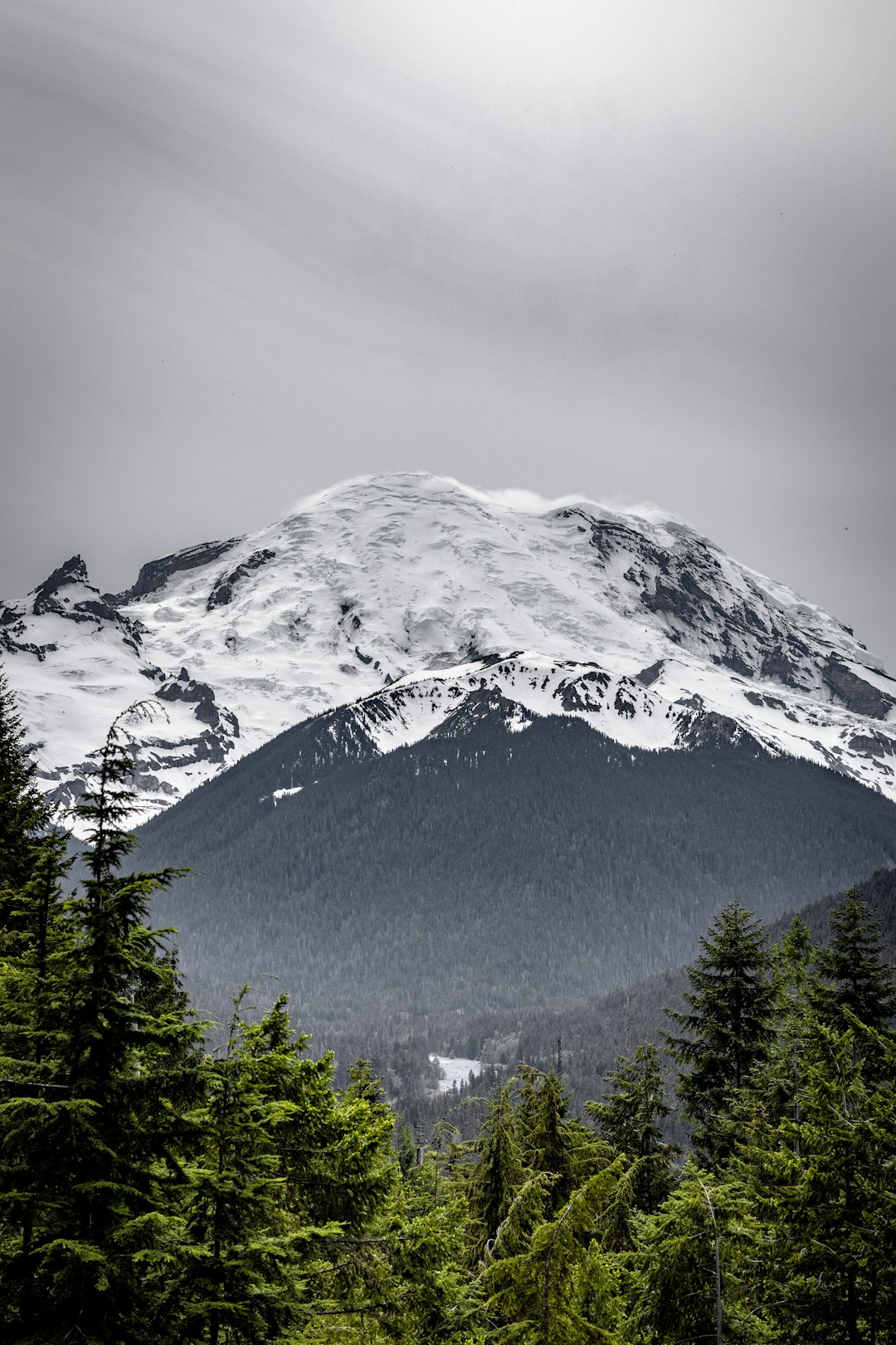 snow capped mountain under gray skies