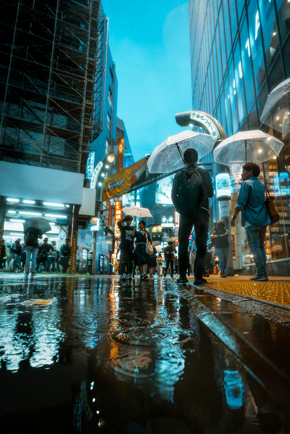 people standing and walking at the streets of the city during day