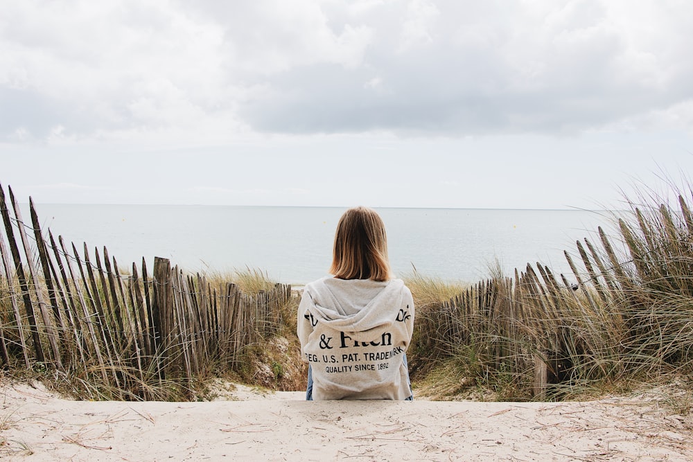 woman sits on shore