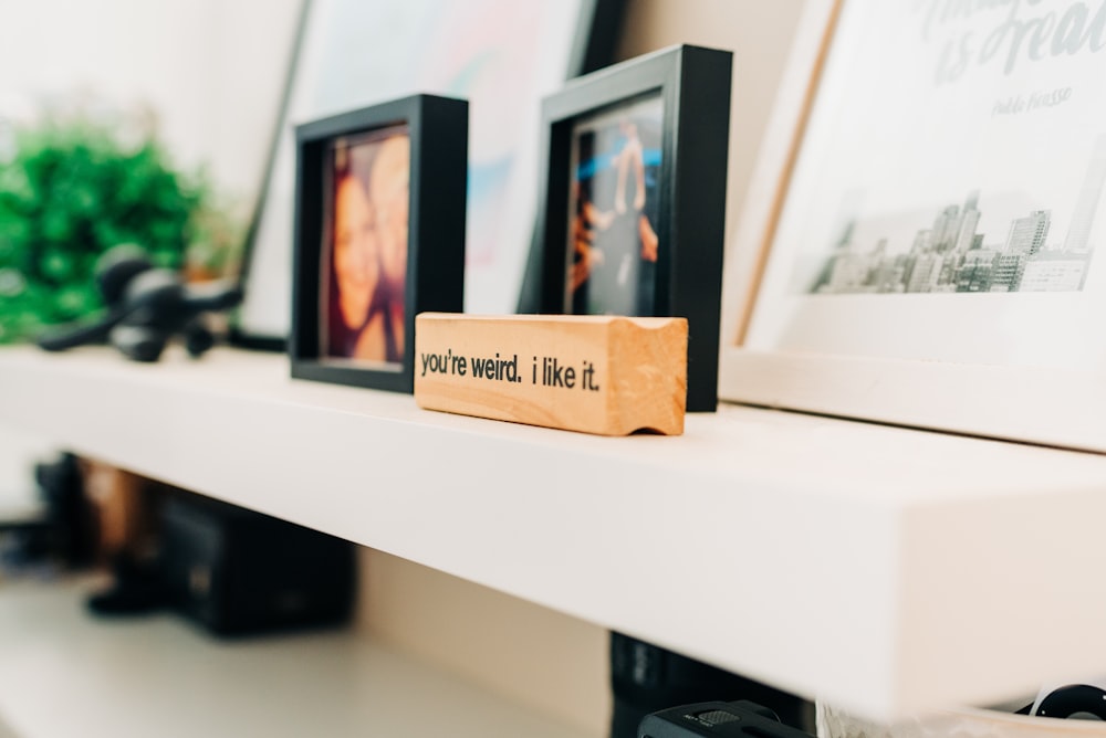 photo of black photo frame on white wooden console table