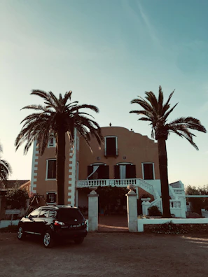 A smiling family standing proudly in front of their luxury villa with golden accents.