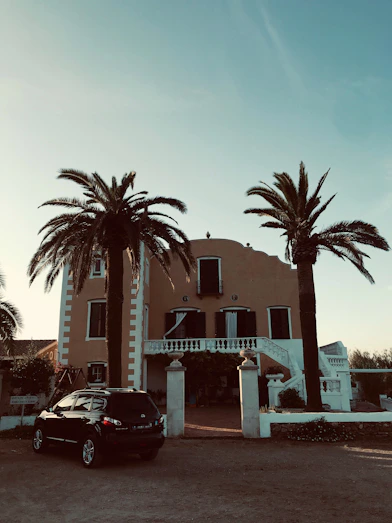 A welcoming Airbnb host greeting guests at a stylish villa entrance.