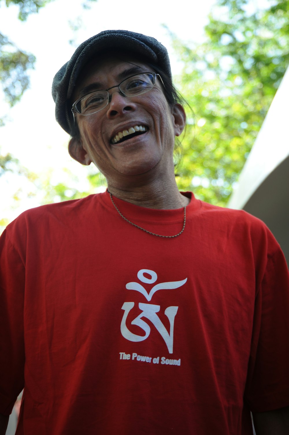 Persona desconocida en blusa roja de cuello redondo tomando selfie al aire libre