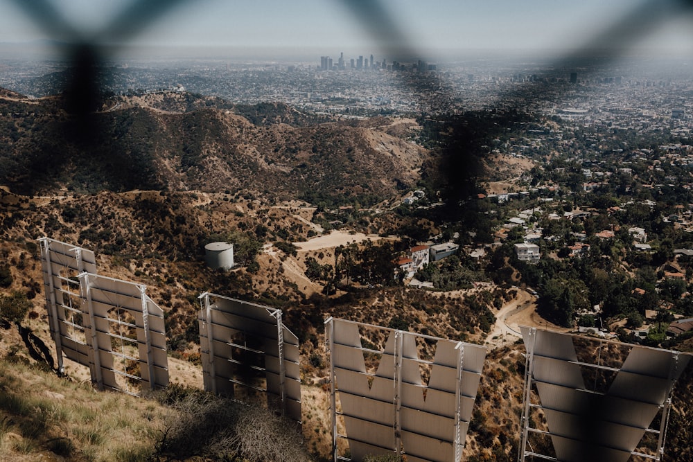 cityscape and Hollywood sign through chain link fence
