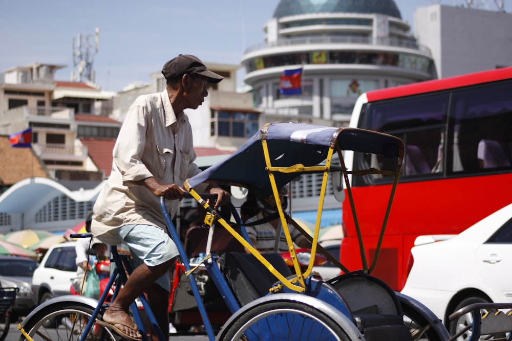 man paddling utility trike near vehicles