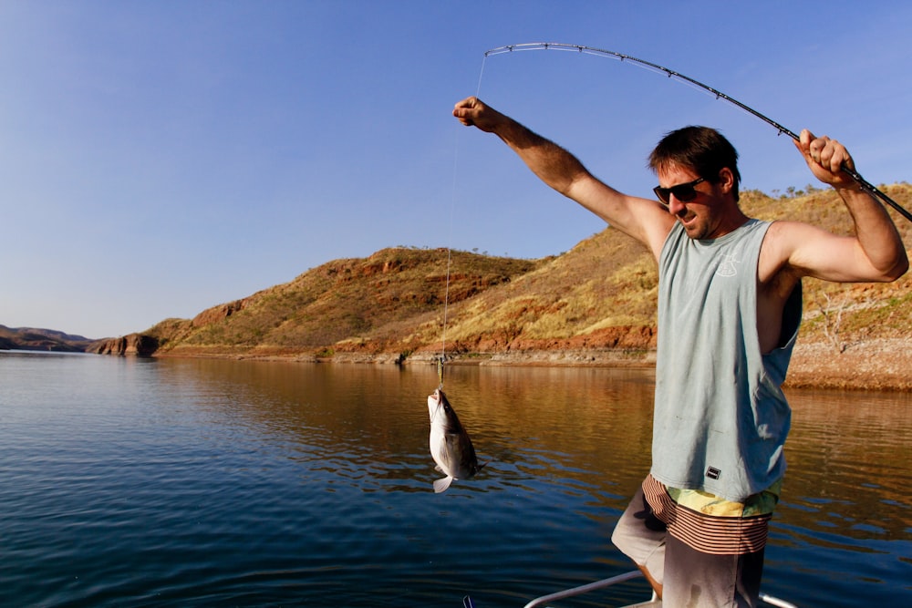 Foto Hombre pescando con su caña de pescar – Imagen Azul gratis en