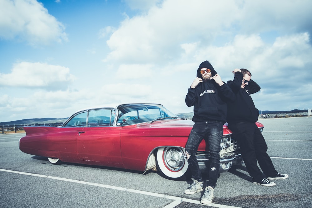 two person sitting in a red car close-up photography