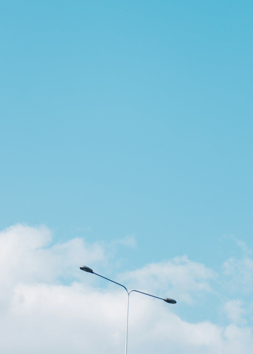 gray street lamp across blue sky