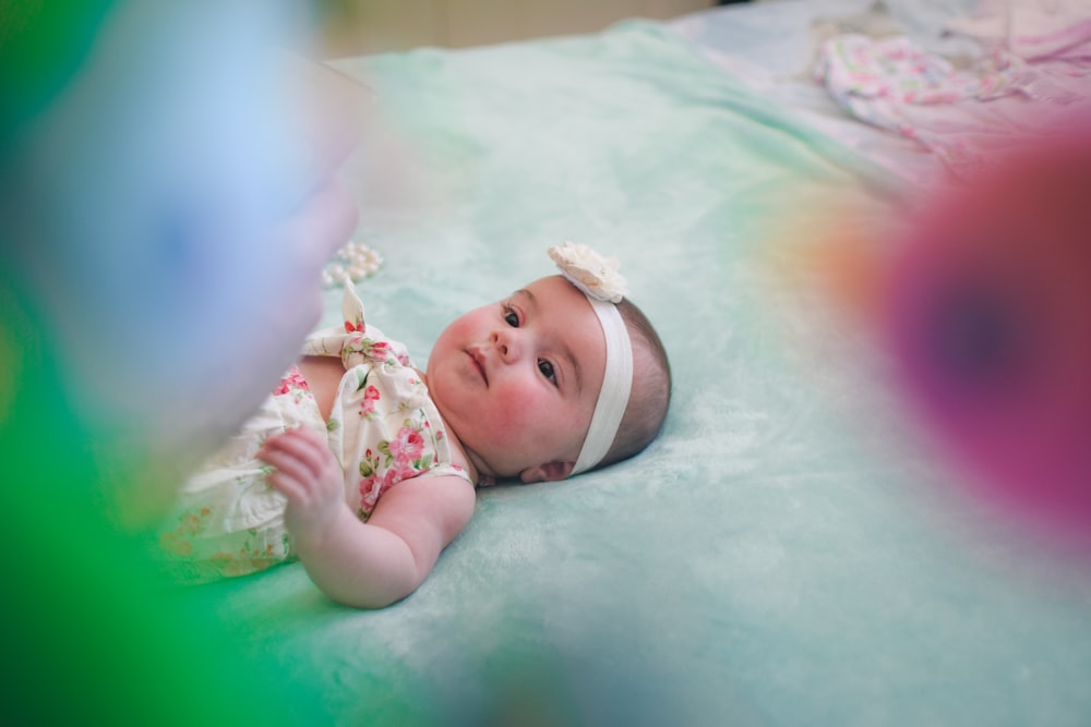 Baby trägt rosa und beige Blumenstrampler